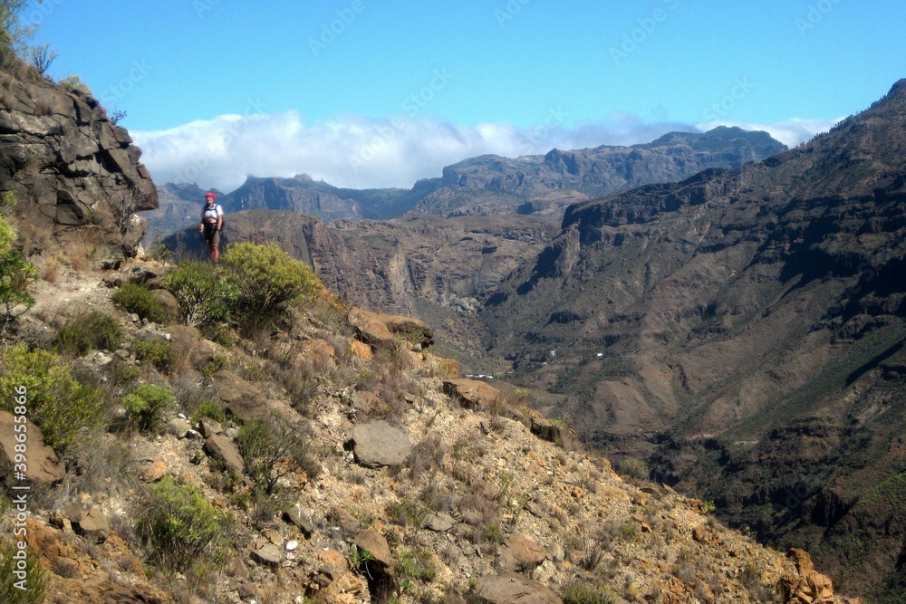 Beautiful mountain landscape during trekking around Montana de Tauro peak. Silhouette of tourist on trail. Gran Canaria, Canary Islands, Spain