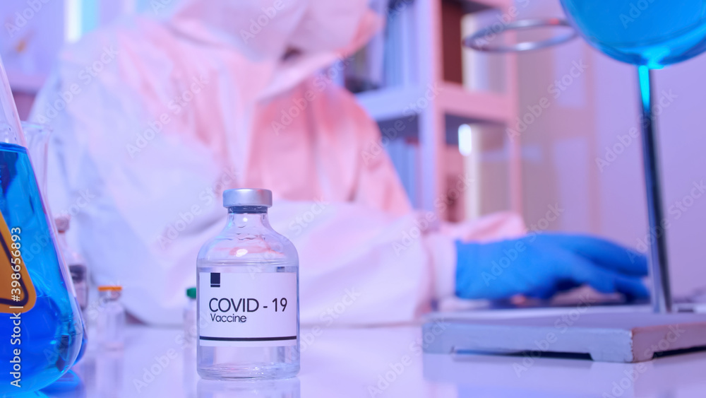 Fototapeta premium Scientist in PPE suit conducts research on the COVID 19 vaccine at a laboratory.