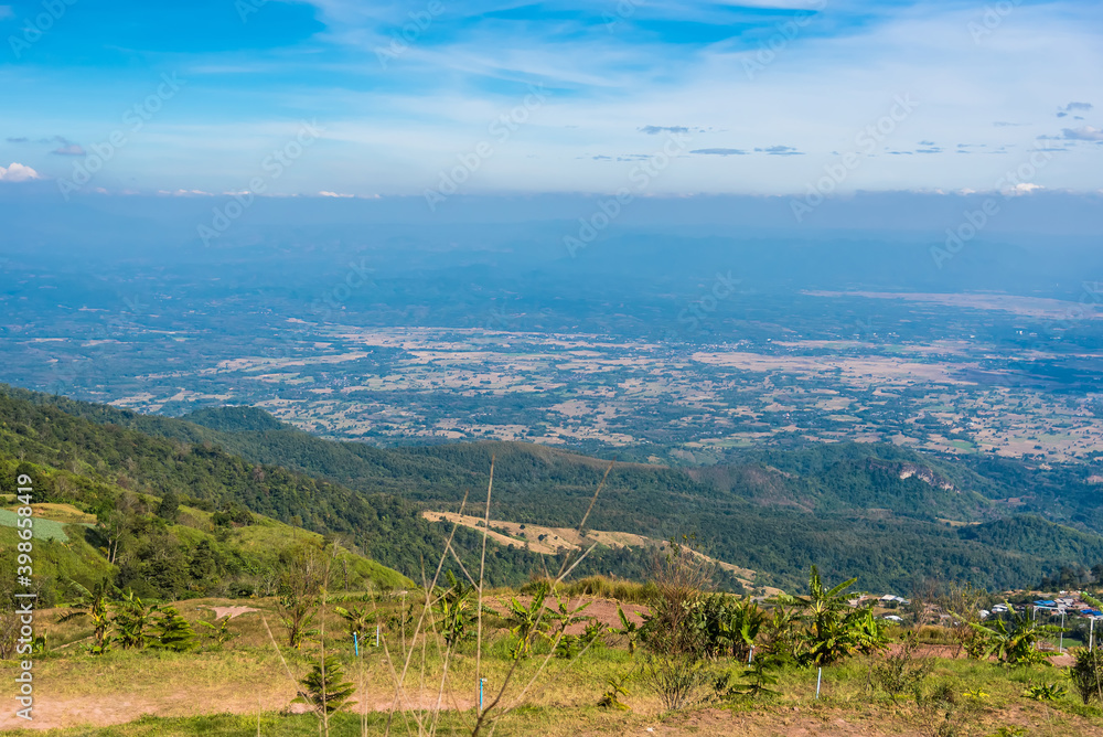 Mountain view morning on top hills and green forest cover with soft mist and blue sky background.Thailand.