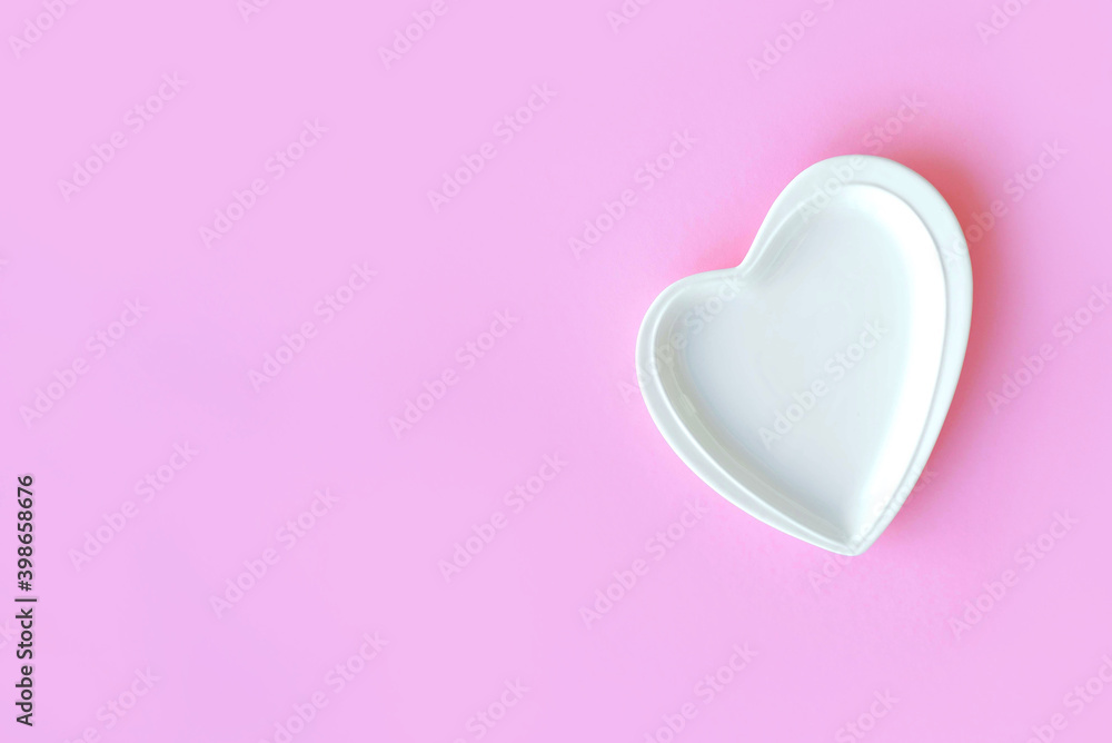 empty white plate in the form of a heart on pink background for valentine's day. restaurant menu. top view with place for text empty white plate in the form of a heart on pink background for valentine's day. restaurant menu. top view with place for text