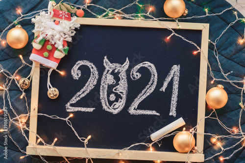 Santa Claus and the inscription 2021. Santa Claus toy and the inscription in chalk numbers 2021. Text 2021