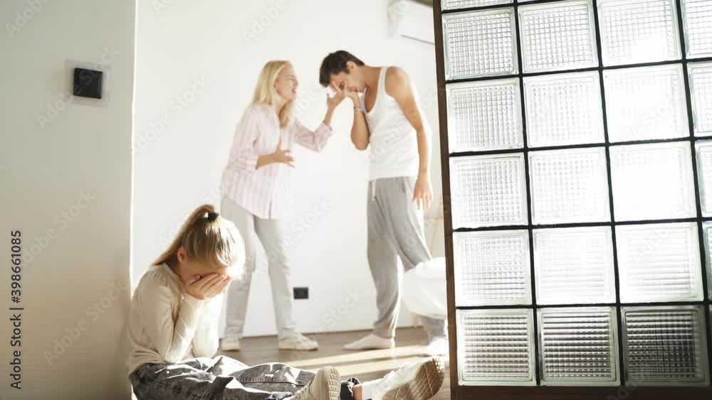 Kid girl is exhausted of hearing her parents yelling at each other, sad child sit depressed. Family conflict, crisis, divorce, break up concept. Kid girl is exhausted of hearing her parents yelling at each other, sad child sit depressed. Family conflict, crisis, divorce, break up concept.