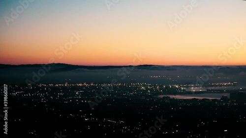 Burnt Orange Sunset Over Twinkling City Lights photo