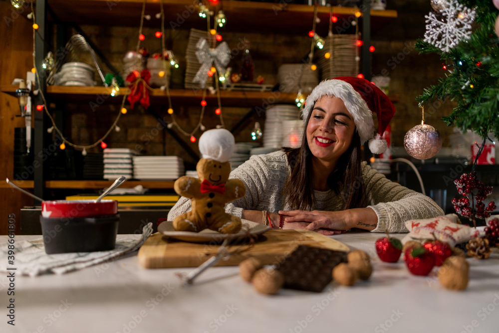 Vegan chef girl cooking sweets in Christmas kitchen next to stuffed cookie doll playing and enjoying Vegan chef girl cooking sweets in Christmas kitchen next to stuffed cookie doll playing and enjoying