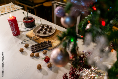 Vegan chef girl cooking sweets wearing santa hat with christmas decoration in christmas kitchen eating chocolates
