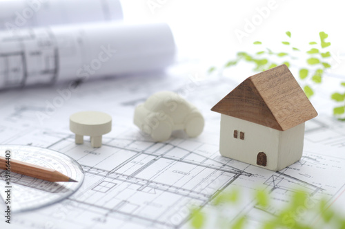 木でできた家の模型とマイホームの設計図のイメージ