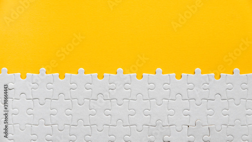 Photography Top view of a white jigsaw puzzle on a yellow background with copy space