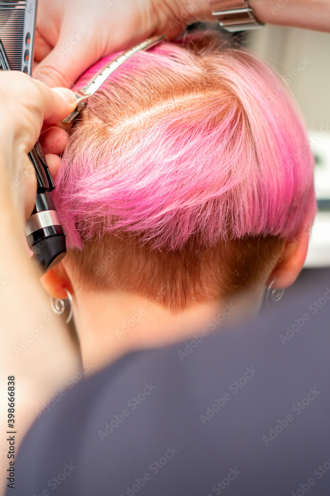 Naklejka premium Hairdresser pinches hair with the clip before doing hairstyle in a hair salon