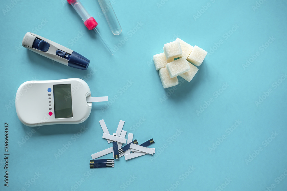 medicine, diabetes diagnostics, healthcare. concept. top view of a blood glucose meter and test strips checking blood sugar levels at home medicine, diabetes diagnostics, healthcare. concept. top view of a blood glucose meter and test strips checking blood sugar levels at home