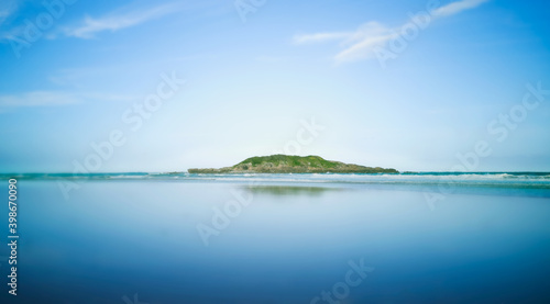 Reflections of Little Muttonbird Island on the leeward side with blue sky background. photo
