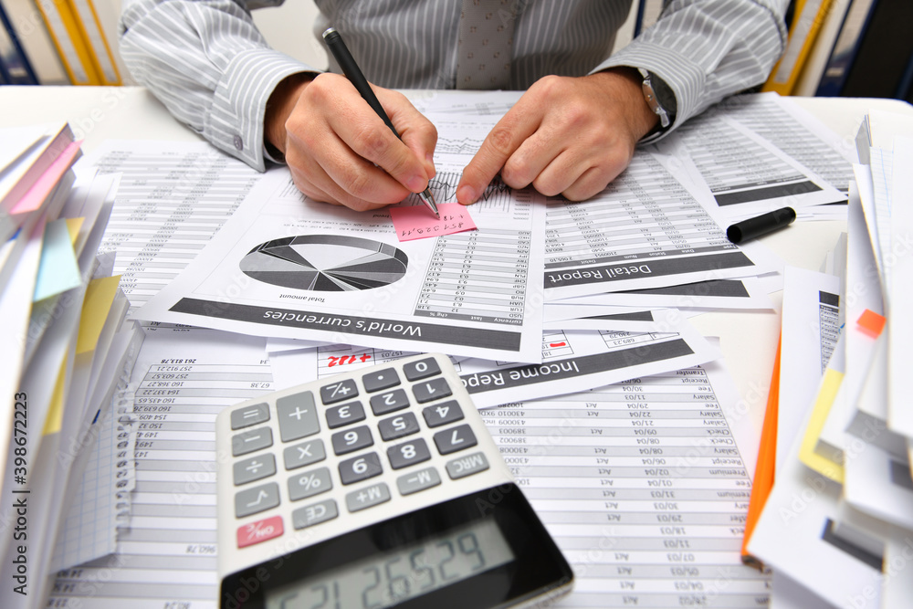 business concept - businessman working with reports in office, table and workspace close view, analyzing financial data, writes and counts business concept - businessman working with reports in office, table and workspace close view, analyzing financial data, writes and counts