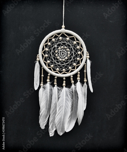 Φωτογραφία Beautiful handmade boho styled dreamcatcher with white feathers and beads against black