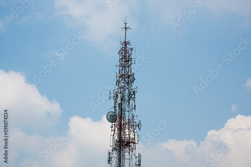 Communication pole on sky background, surrounded with white cloud