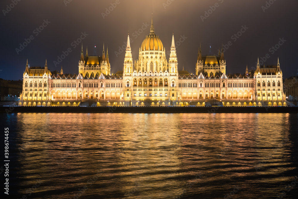 Hungarian Parliament viewed at night on the Danube river in Budapest