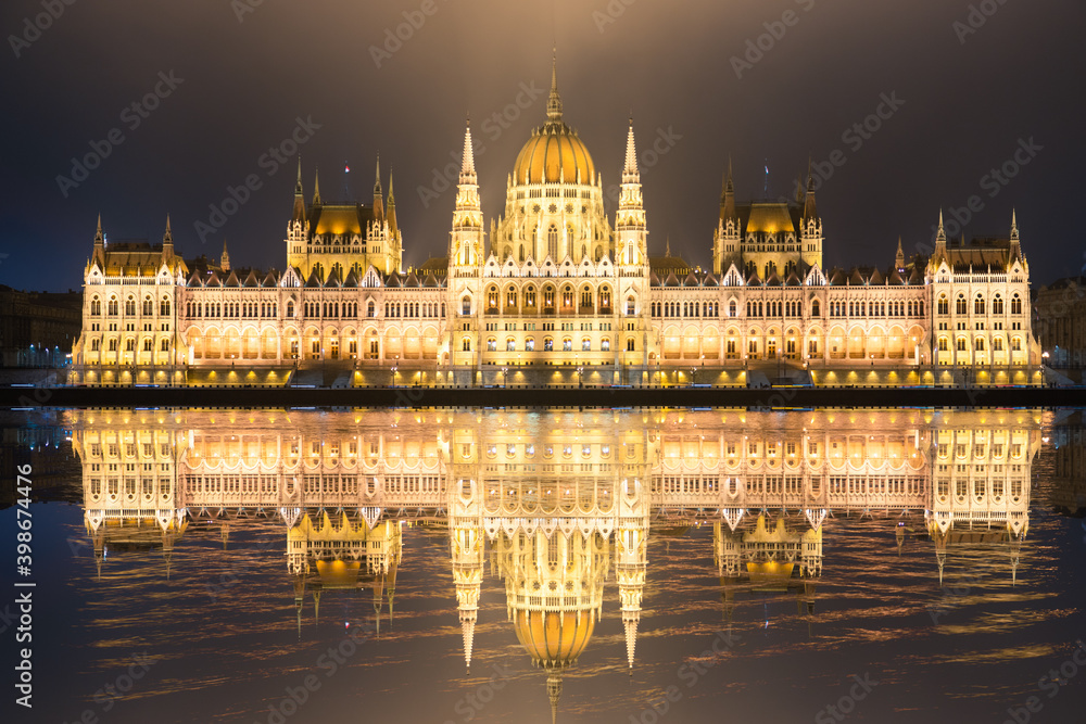 Fototapeta premium Hungarian Parliament with reflection viewed at night on the Danube river in Budapest