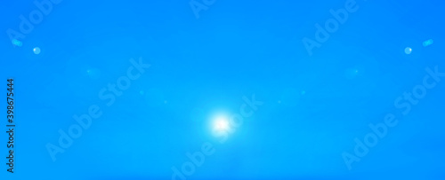 Blue sky and glare of rays in different directions from the star of the sun or moon. Illustration for inserting text. © A Stock Studio