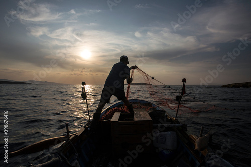 Fisherman catching fish in fishing net