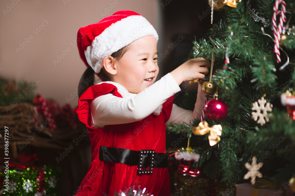 young girl decorating Christmas tree at home young girl decorating Christmas tree at home