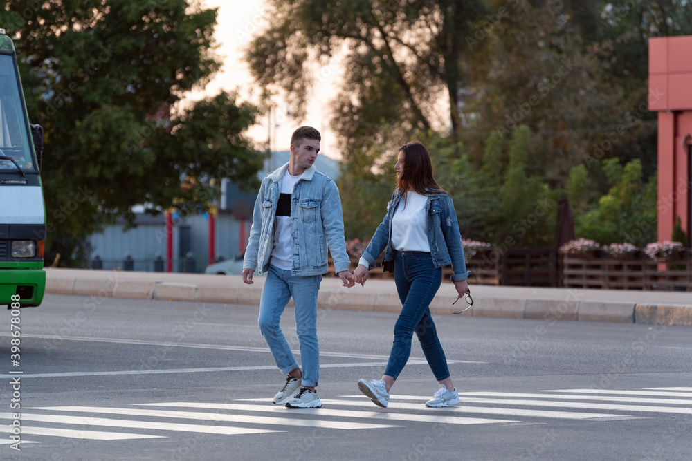 Loving couple crosses the street holding hands. Full size photo