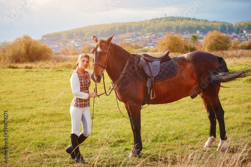 Portrait of a beautiful girl in a classic tracksuit rider with her horse