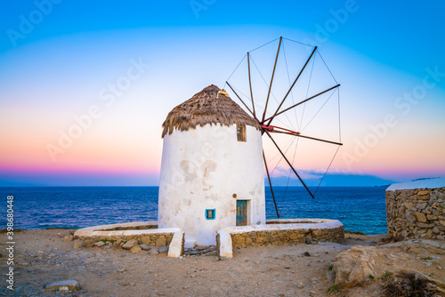 Fototapeta Naklejka Na Ścianę i Meble -  Traditional white windmill near the sea coast at sunrise