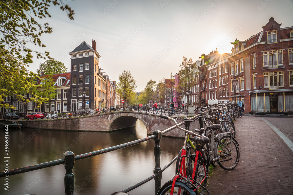 Bike over canal Amsterdam city. Picturesque town landscape in Netherlands with view on river Amstel
