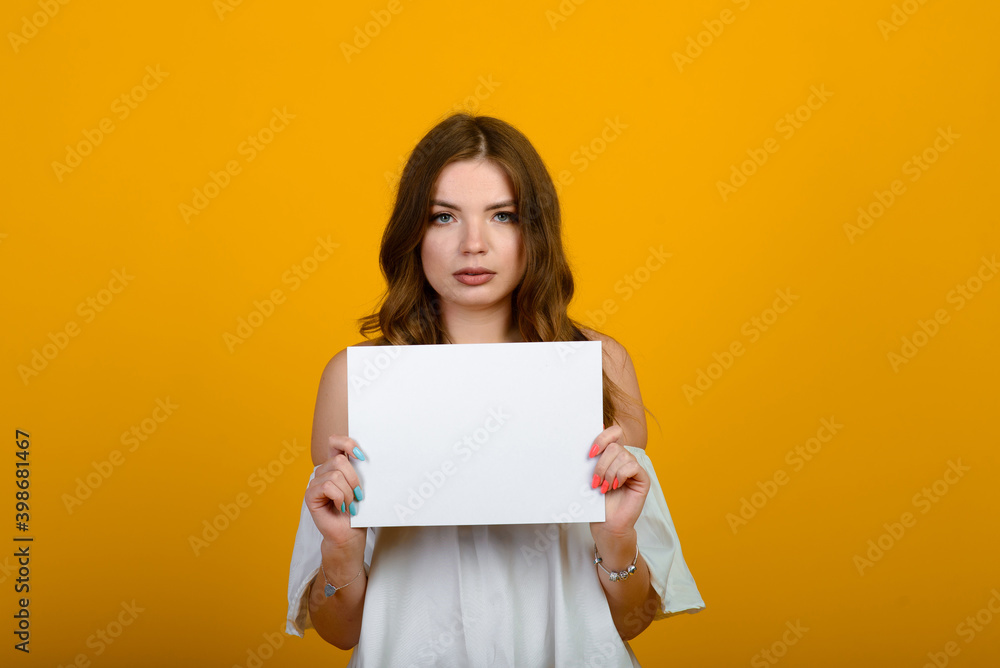 Dark-haired young woman with a smile and big suprised eyes posing on yellow background. Dark-haired young woman with a smile and big suprised eyes posing on yellow background.
