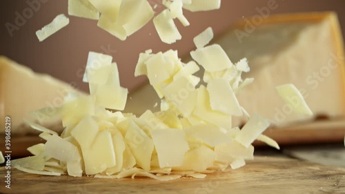 Super Slow Motion Shot of Parmesan Shavings Falling on Wooden Board at 1000 fps. photo