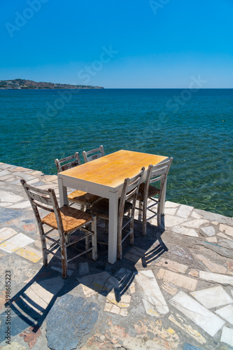 Magnificent panoramic view on a coast beauty. Peaceful place. Served tables. Table and chairs at a traditional greek restaurant by the beach. Lerapetra  Crete.