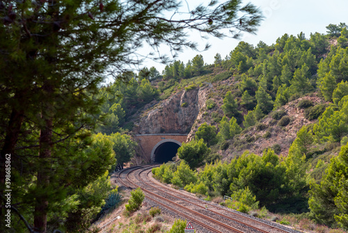 Railway tunnel in the mountaine, green forest and rail tracks in Provence