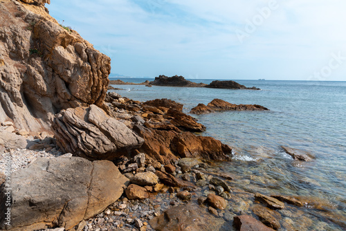 Coastline rocks and surf, seascape, blue sky, clear horizon