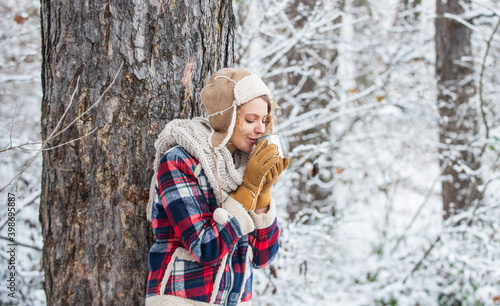 Girl hiker drink cup of hot coffee. Winter adventure. Wanderlust. Winter hike. Warm yourself up. Woman winter drink. Girl enjoy mulled wine. Woman in hat drinking tea in forest. Hiking and traveling