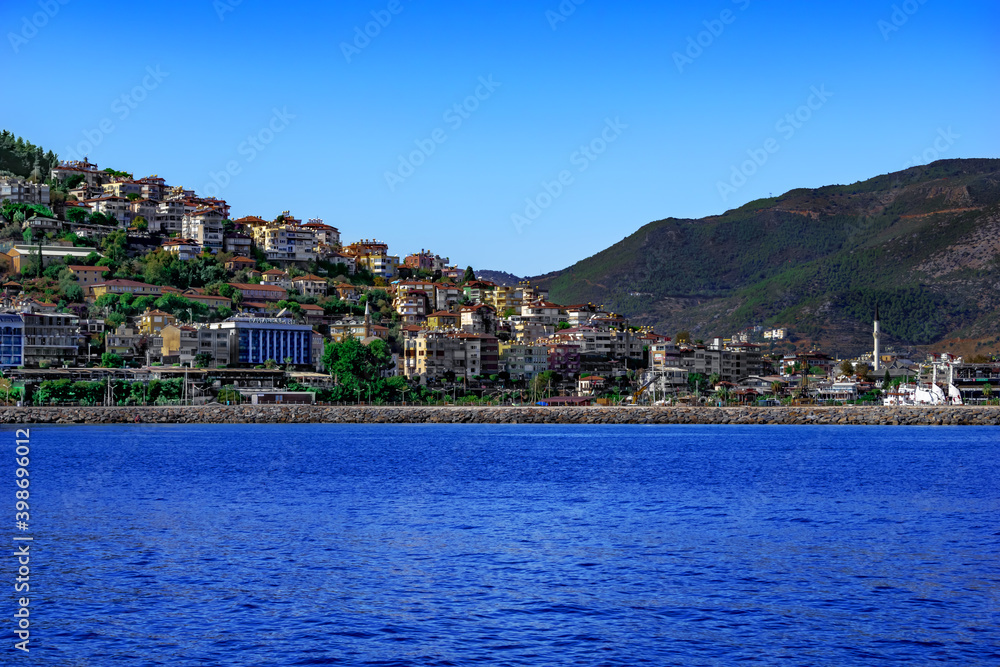 Alanya, Turkey - October 22, 2020: Beautiful coastline landscape of Alanya. View from the Mediterranean Sea to the modern tourist Turkish town among the mountains