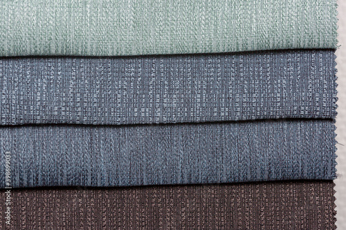 Opaque soft tones of green, marine blue and light shades of blueish gray interior decoration sample color swaps of textured curtain fabric for comparison and feel