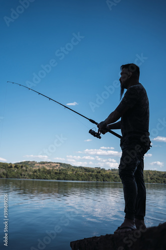 Profile of a young asian man fishing - Asian man with beard and shirt camouflaged in the river.