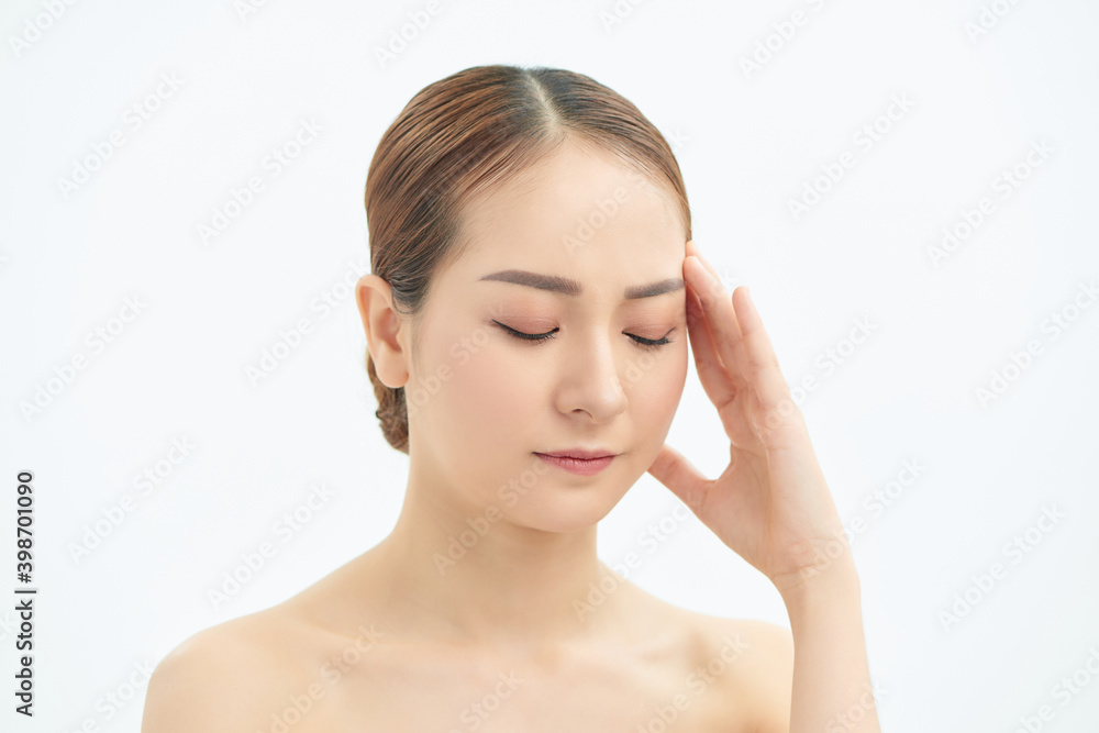 Portrait of beautiful young Asian woman with bare shoulders touching her temples feeling stress, on white background Portrait of beautiful young Asian woman with bare shoulders touching her temples feeling stress, on white background
