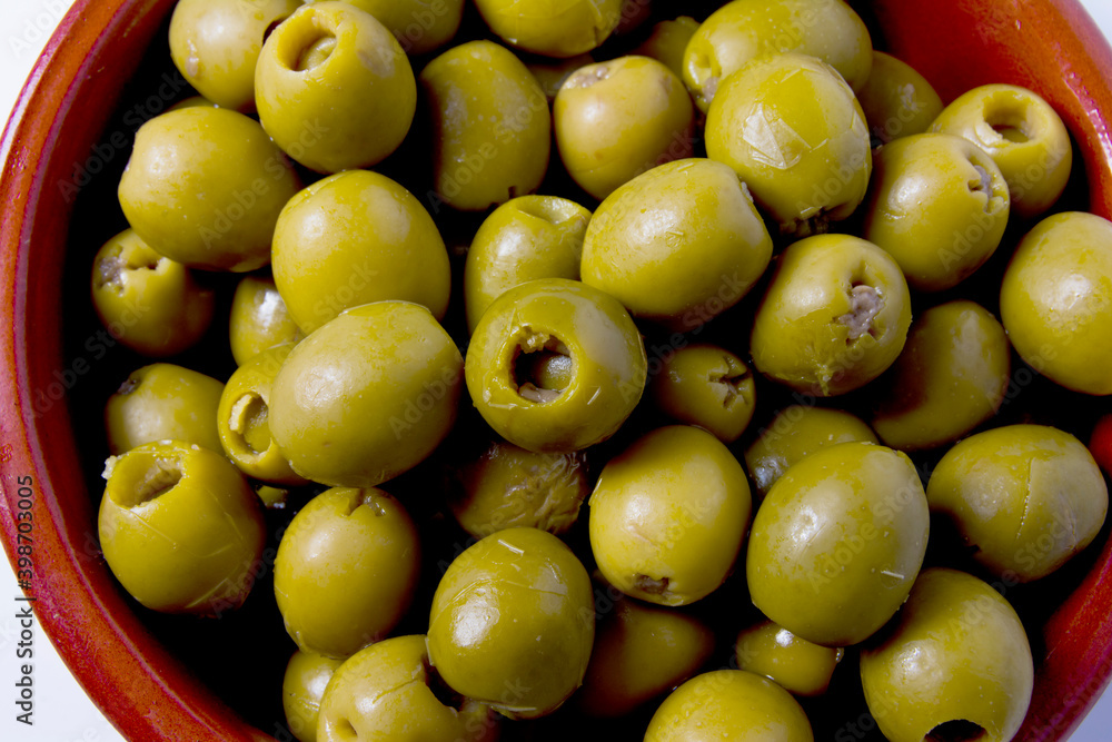 Olives stuffed with anchovies in a ceramic bowl and white background Olives stuffed with anchovies in a ceramic bowl and white background