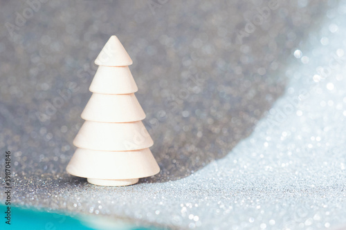Christmas and New Year holidays card. Wooden xmas tree on blue sparkle abstract background, reflection