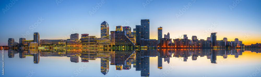 Canary Wharf business district of London at sunrise with reflection