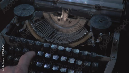 Man Prints With Vintage Soviet Typewriter in the Dark photo