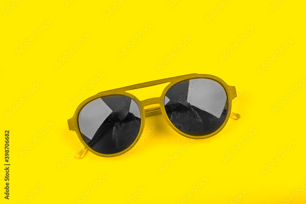 Gray modern fashionable sunglasses on yellow background. Trendy colors 2021 concept Gray modern fashionable sunglasses on yellow background. Trendy colors 2021 concept