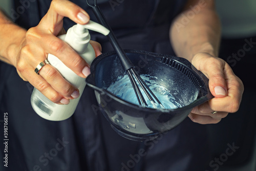 Tableau sur toile Hairdresser calorist mixes ingredients for hair coloring.
