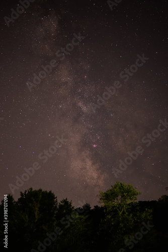 summer night sky with milky way galaxy shining trough stars and planets