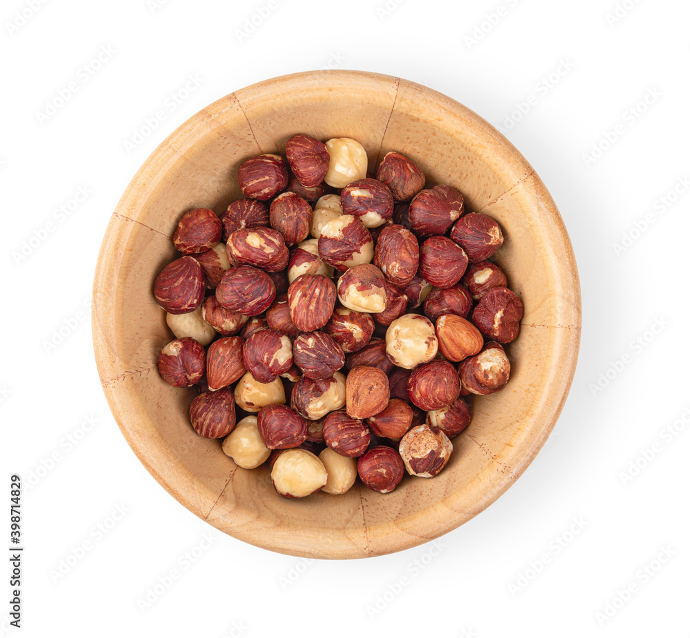Fototapeta premium Hazelnuts in a wooden bowl on a white background, top view