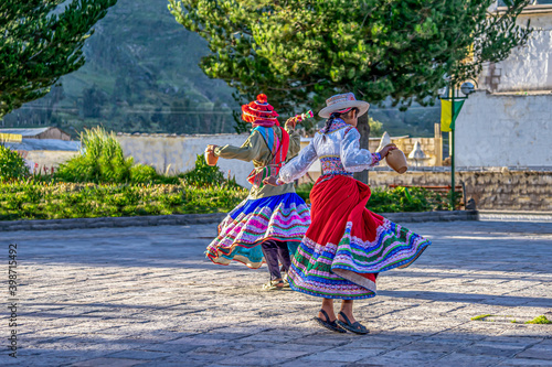 Peru, in the village of Chivay near the Colca Canon , 
joung girls dancing in traditional dresses around a fountain  photo
