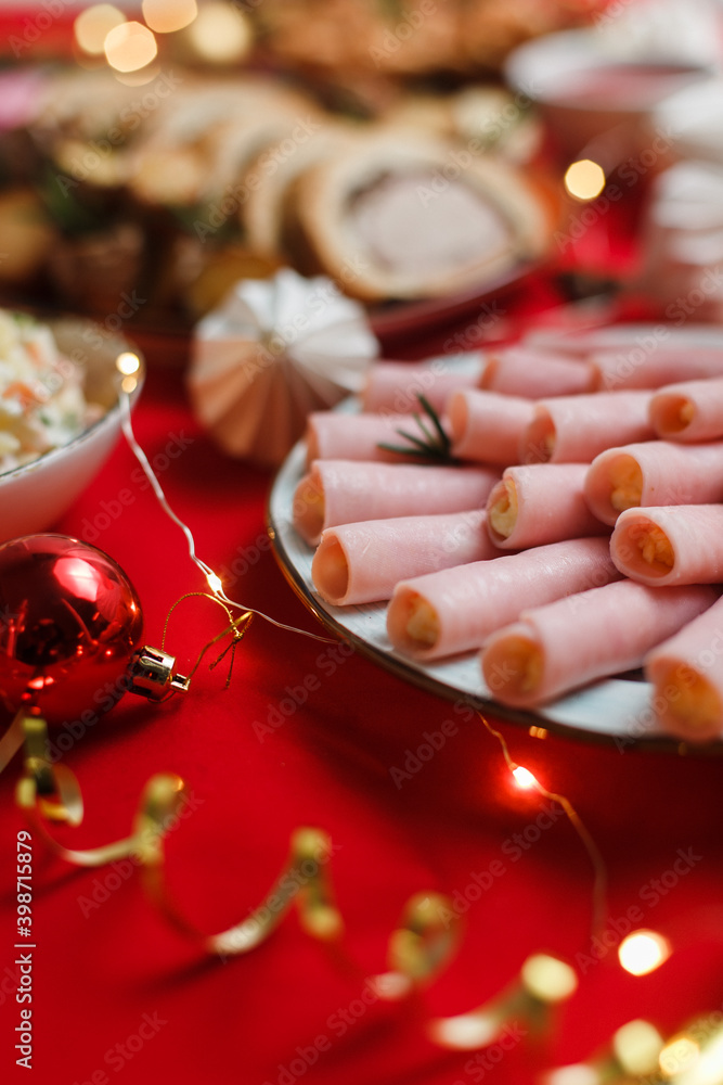 
Festive table with Christmas food and snacks. Delicious European dishes on New Year's Eve on the table on a red background