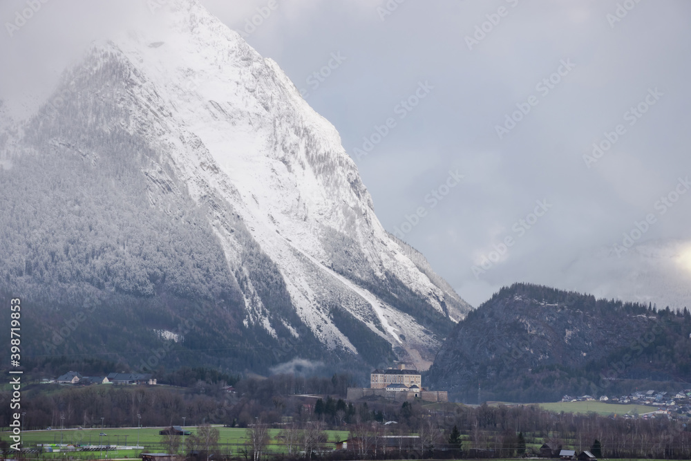 Winter landscape with snow covered Grimming mountain and Trautenfels Castle in the district of Liezen in Styria, Austria