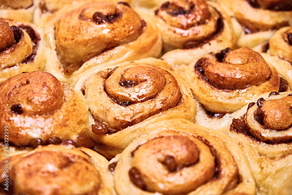 Cinnabon cinnamon buns. Baked with raisins and nuts in sugar syrup. Home baking. Cinnabon cinnamon buns. Baked with raisins and nuts in sugar syrup. Home baking.