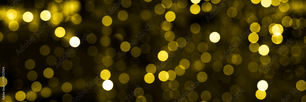 blurred glowing lights of garlands of golden color, bokeh. banner. toned in illuminating and ultimate gray, trend color of the year 2021 blurred glowing lights of garlands of golden color, bokeh. banner. toned in illuminating and ultimate gray, trend color of the year 2021
