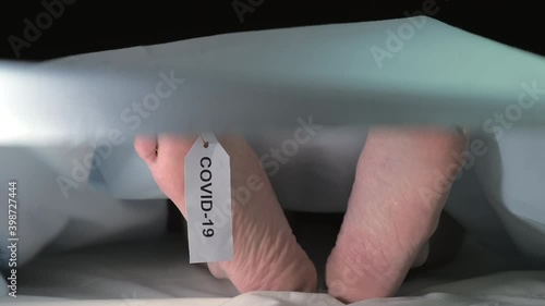 The look of the feet of the cold dead body on the morgue with the covid-19 tag during the pandemic photo